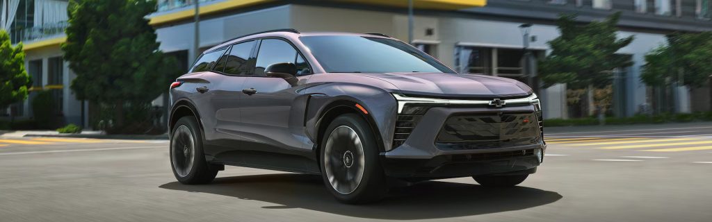 White Chevrolet Blazer EV driving on urban street.