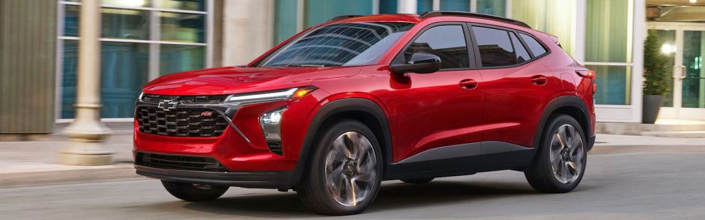 Red Chevrolet SUV driving through an urban area.