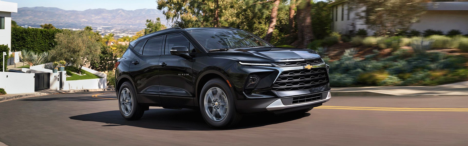 Black Chevrolet Blazer SUV driving on a road.